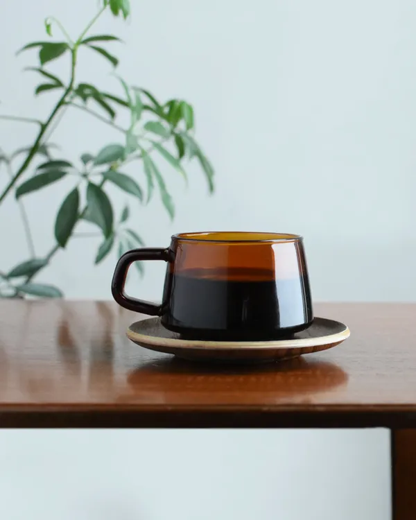 The Sepia cup on its saucer on a wooden table