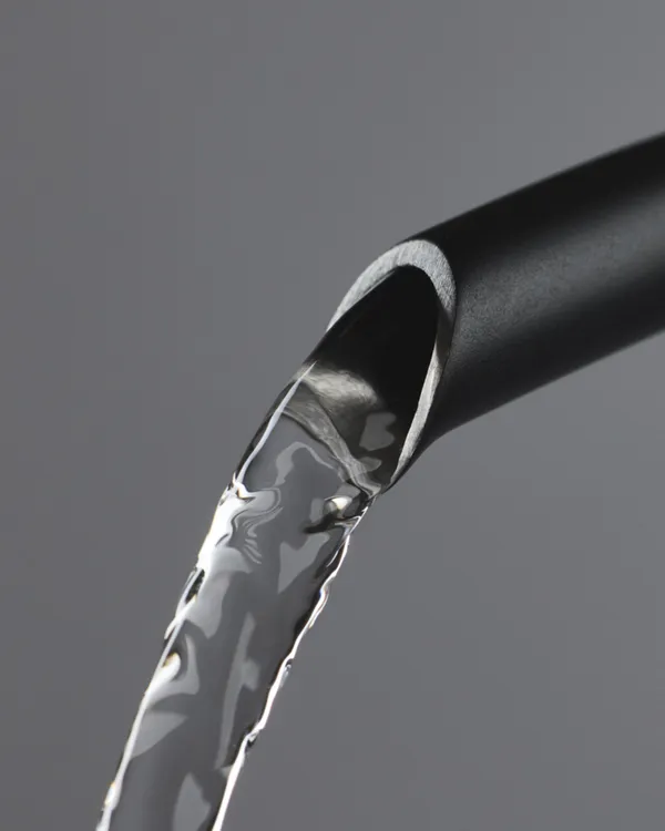 Water pouring in a thin stream from the gooseneck spout