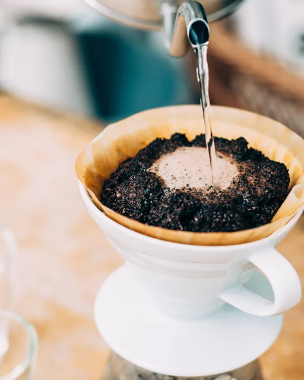 Pouring water over coffee in the white V60 dripper